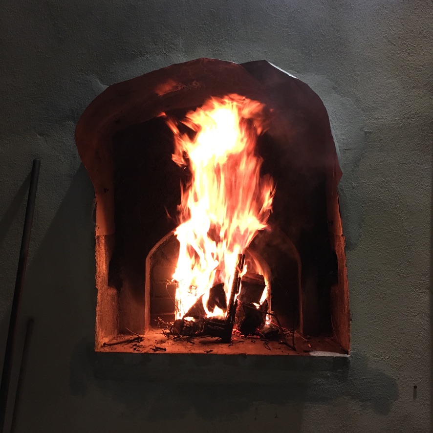A fire burning in the outdoor oven at Villa Fontanella